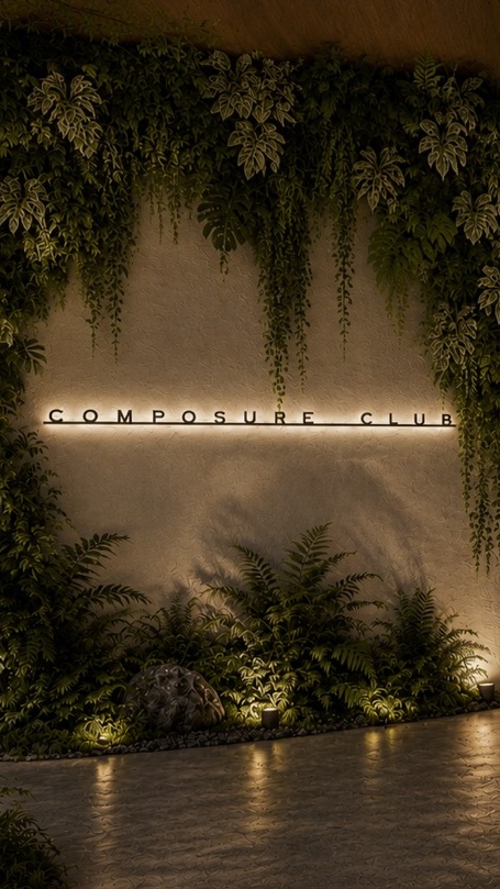 Illuminated Composure Club signage on a plant-draped stone entrance wall at the Boca Raton storefront